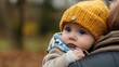 © Yuliya - Precious Moments: Baby in Knitted Hat. A heartwarming image of a baby snuggled close, wearing a cozy yellow knitted hat.  Captures the innocence and love of a tender moment.