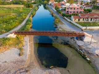 Wall Mural - Aerial view of a metal bridge over a calm waterway.