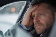 © Milos - A man in a car showing signs of frustration and concern, with snow covering the window, illustrating the stress and challenges faced during winter travels.