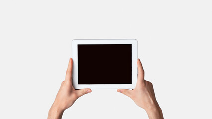 Poster - Male hand holding tablet computer on light background, mockup for design. Panorama
