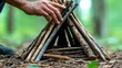 © CHA - A person building a shelter using natural materials in the forest.