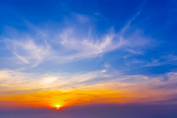 Wall Mural - Amazing view of sunset sky with sun setting high cirrostratus clouds with blue-orange gradient of atmosphere