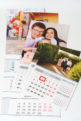 Wall Mural - tear-off calendars with family photos on a white table. 