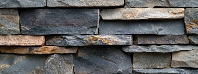 Poster - A close-up view of a textured stone wall made of various slate pieces.