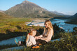 © EVERST - Mother playing with daughter outdoor family vacations travel in Albania, parent and child having fun together mountains and river landscape