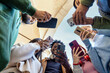 © Lomb - Diverse friends sharing social media content on smartphones outdoors