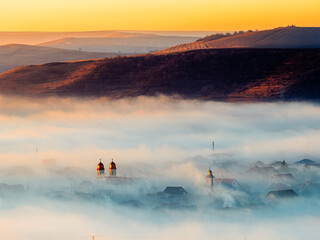 Orthodox church old town landscape with dramatic fog and mist at sunset