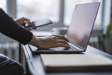 Poster - Woman's fingers nimbly typing on a cutting-edge laptop keyboard, with a blurred office scene behind