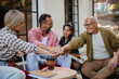 © Westend61 - People at community meeting stacking hands to symbolize unity