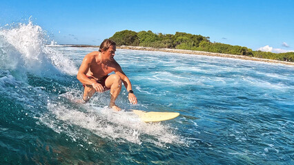 Aufkleber - Surfer skillfully navigating vibrant waves in a tropical ocean. Maldives