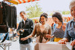 © Westend61 - Group of people shopping at an outdoor flea market.