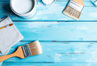 © Ionela - Paintbrushes and paint cans on a blue wooden background, suggesting a painting or home improvement project