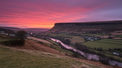 Poster - A colorful sky transitions from gold to purple as the sun sets over a winding river surrounded by vibrant fields, creating a peaceful rural atmosphere