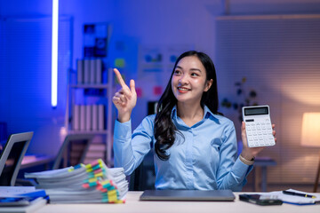 Wall Mural - A woman is holding a calculator and pointing to the number 2