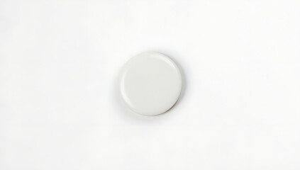 Aufkleber - Small glossy white circular pin badge sits alone on a clean white surface in a minimalist setting._00001_
