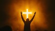 © Lion - worship scene with a silhouetted figure raising hands towards a bright illuminated cross