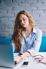 Fototapete - Attractive female graphic designer searching information on internet websites using good wifi connection on laptop computer, charming young woman downloading file for working on modern netbook
