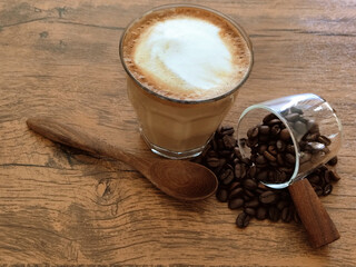 Wall Mural - Hot latte with coffee beans on a wooden table