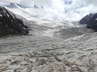 Wall Mural - Expansive glacier stretches across a mountainous terrain, reflecting the calmness of a cloudy day in nature beauty