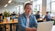 © Tom - A young man with Down syndrome working on a laptop in a bright, modern office, exuding a sense of professionalism and confidence.