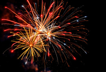 colorful fireworks exploding in the night sky, with bright bursts of red, yellow, and white sparks a