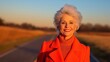 © Vasiliy - Cheerful woman in red coat at sunset. Vibrant aging concept