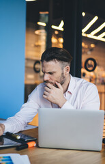 Fototapete - Smart casual freelancer searching web publication via modern touch pad for networking, young skilled man connecting to coworking internet for doing distance job and develop business project