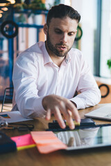 Fototapete - Smart casual freelancer searching web publication via modern touch pad for networking, young skilled man connecting to coworking internet for doing distance job and develop business project