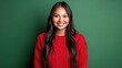 © Darcraft - Cheerful young Native American woman with long dark hair in a bright red sweater standing against a solid green background..