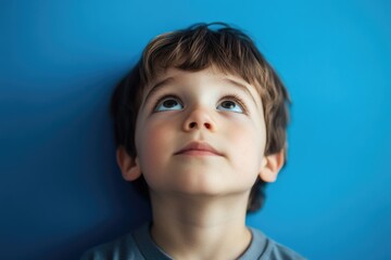Aufkleber - A curious young boy gazing up at the clear blue sky, ideal for use in illustrations about childhood wonder or curiosity