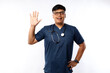 © ArvStd - Healthcare workers and preventing virus concept. Friendly looking smiling asian male doctor, physician in scrubs waving hand to say hi, hello, greeting patient, nice to see you