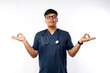 © ArvStd - Healthcare workers and preventing virus concept. Calm and patient asian male doctor, nurse in scrubs staying relaxed, meditating with eyes closed and happy smile, white background