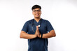 © ArvStd - Healthcare workers and preventing virus concept. Smiling handsome asian male nurse, physician in scrubs smiling, hold hands together over chest in namaste, greeting gesture