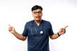 © ArvStd - Enthusiastic man doctor, medical worker in blue scrubs, pointing fingers sideways, left and right, showing health clinic promo, standing isolated white background