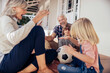 © Marko Geber - Happy grandparents playing soccer with grandchildren on home porch