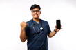 © ArvStd - Successful cheerful asian female doctor, nurse in scrubs fist pump in rejoice, showing smartphone screen app and looking pleased at camera