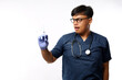 © ArvStd - Confident asian male nurse, doctor in medical rubber gloves, holding syringe with vaccine, standing white background