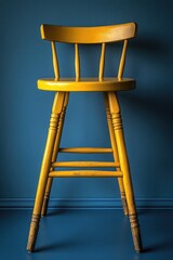 Aufkleber - A single yellow wooden chair placed against a bright blue wall, simple and minimalist design