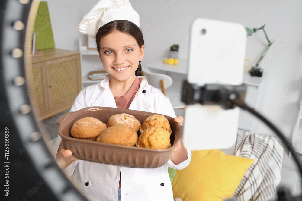 Cute chef with tasty muffins recording video at home