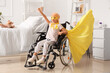 © Pixel-Shot - Little girl after chemotherapy dressed as superhero with yellow ribbon in wheelchair at hospital. Childhood cancer awareness concept