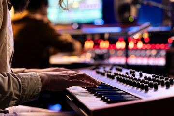 Leinwandbilder - Male musician performing a hit song on electronic keyboard in recording studio, playing notes on midi controller to edit in post production. Artist singing in control room. Close up.