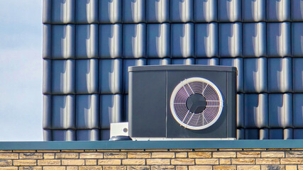 Wall Mural - air source heat pump unit installed outdoors at a modern home with solar panels in the Netherlands