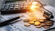 © Gambar Upi - A light bulb, a pen, a calculator and some copper euro cent coins lie on top of an electricity bill