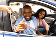© Prostock-studio - Car Sales. Manager giving new auto key to happy young black couple at dealership store, selective focus. Excited African American customers buying vehicle from salesman seller at automobile showroom