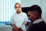 Rude Patient Checking his Phone During Medical Consultation. Doctor offended by the impolite behavior of a man during examination
