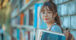 © TrendyImages - Asian Student with Books in Library, Ready to Learn