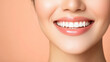 © UMPH.CREATIVE - close up of Asian woman with bright smile, showcasing her healthy teeth and radiant skin against soft peach background. Her joyful expression conveys warmth and positivity