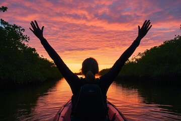 Poster - A person in a kayak celebrates at sunset, surrounded by mangroves and vibrant skies.