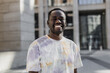 © Cavan Images - Cheerful African American young man standing near urban building