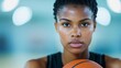 © fotogurme - A close-up of a women’s basketball player holding the ball with intensity, her jersey showing sweat marks, symbolizing effort and dedication